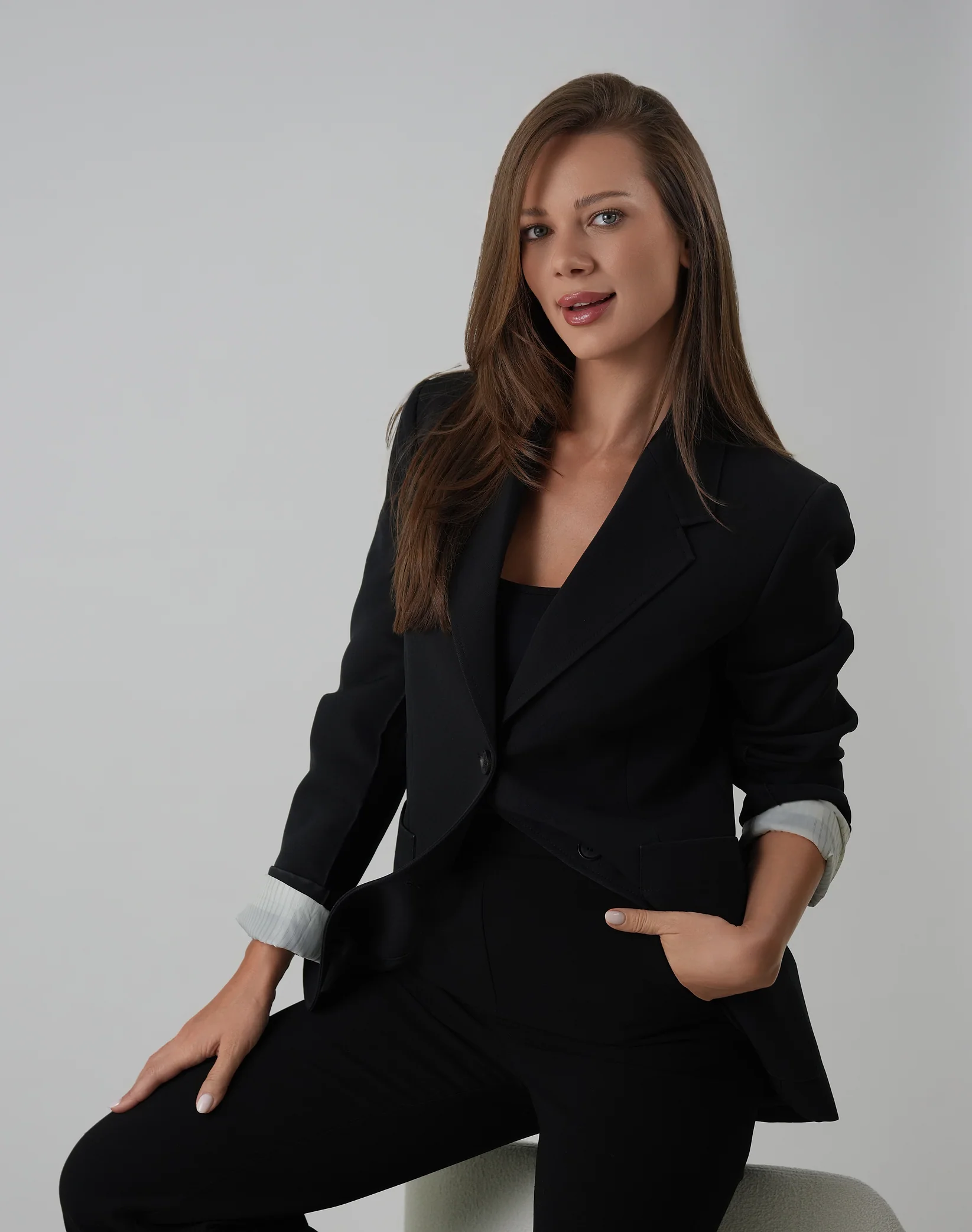 Roxana Diaconu seated in a black suit.
