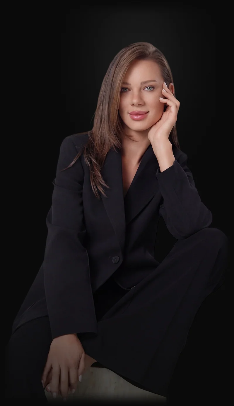 Roxana Diaconu seated in a black suit, her hand at her cheek.