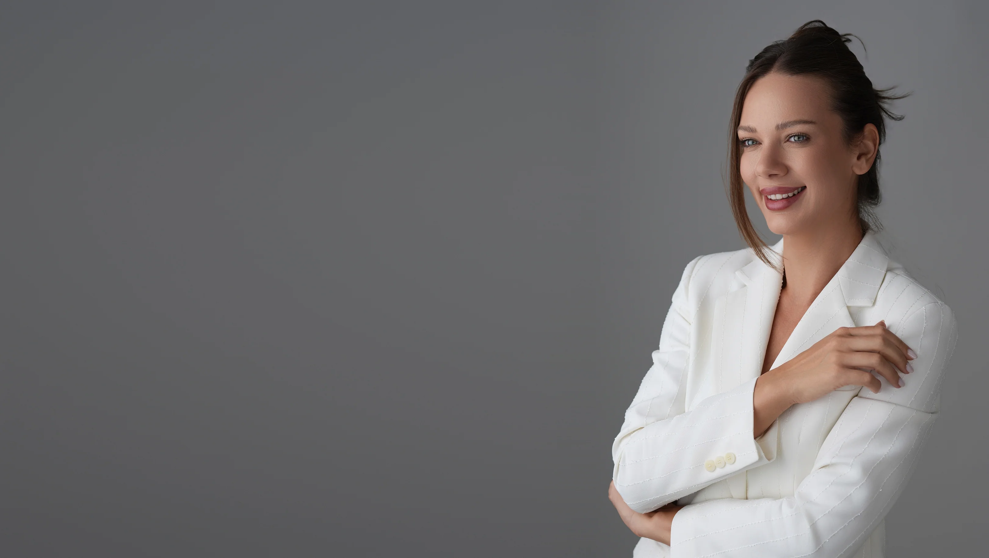 Roxana Diaconu in a white blazer, smiling.